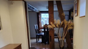 A spacious room with a wooden floor, a dining area with chairs and a table, and a large window providing natural light. - Schöne Große Ferienwohnung für 1-4 Gäste, zum Entspannen Bestens Geeignet (Frielendorf)
