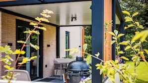 Un espacio al aire libre con patio, una parrilla, una mesa y sillas.