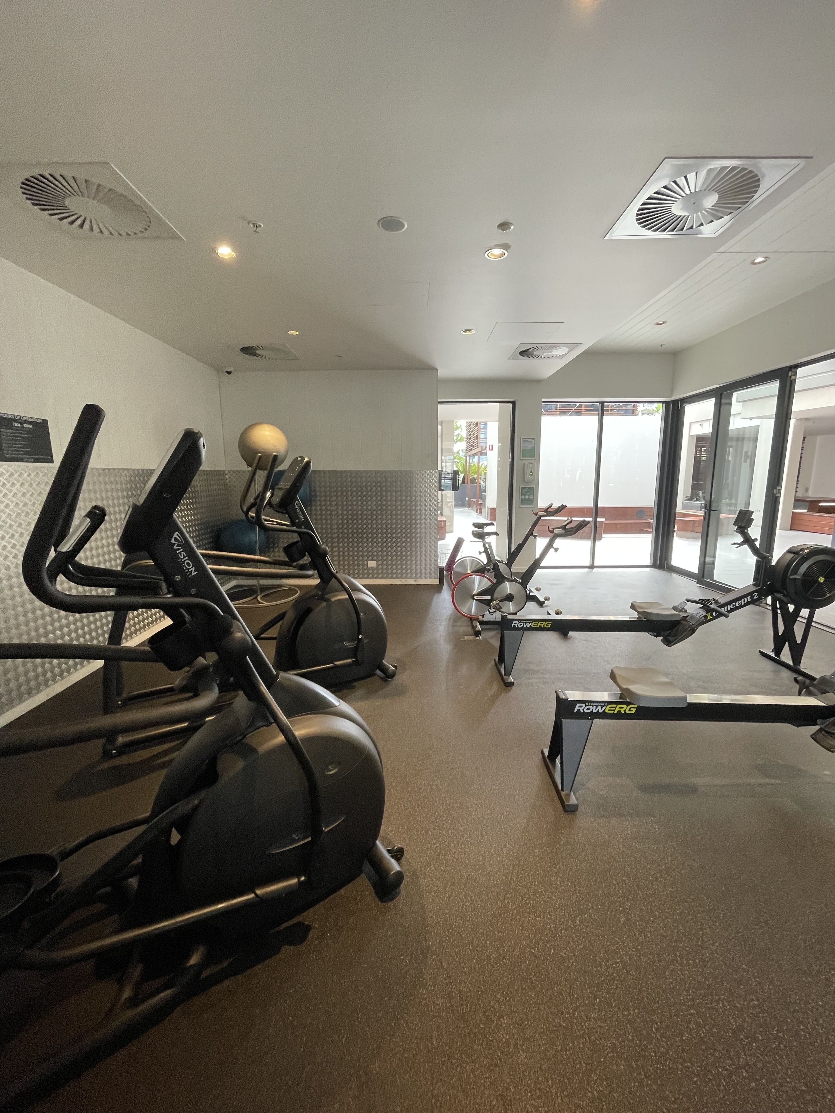 A gym with stationary bikes, treadmills, and an elliptical machine.
