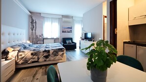 A modern bedroom with a bed, bedside table, and a potted plant. - Holiday Homes Aparthotel Milano (Milan)
