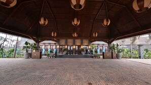 An open-air pavilion with a brick floor, wooden ceiling beams, and hanging light fixtures. - Maira Resort and Convention centre (Arang)