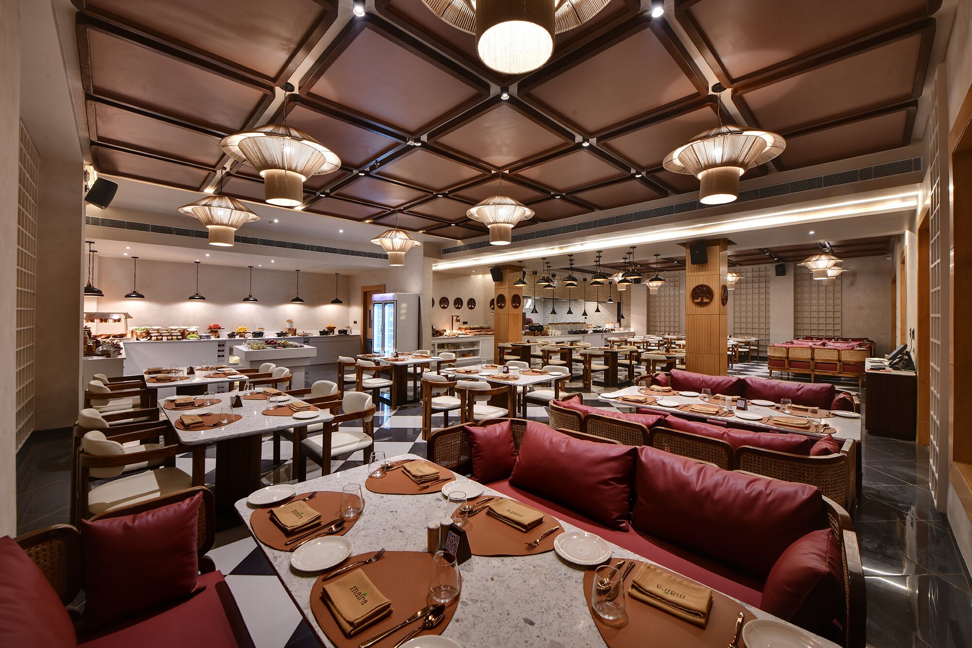 A spacious restaurant with multiple dining areas, including booths and tables, and a visible kitchen area.
