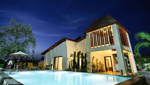 A modern two-story house with a swimming pool, large windows, and a well-lit entrance. - Maira Resort and Convention centre (Arang)