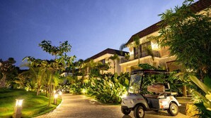 A golf cart parked in front of a resort building at dusk. - Maira Resort and Convention centre (Arang)