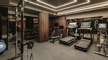 Un gimnasio moderno con cintas de correr, elípticas y pesas.