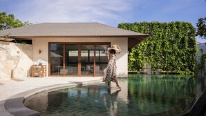A woman walking in a pool area with a house in the background. - Poco Poco Villas by Aayan (Kutuh)