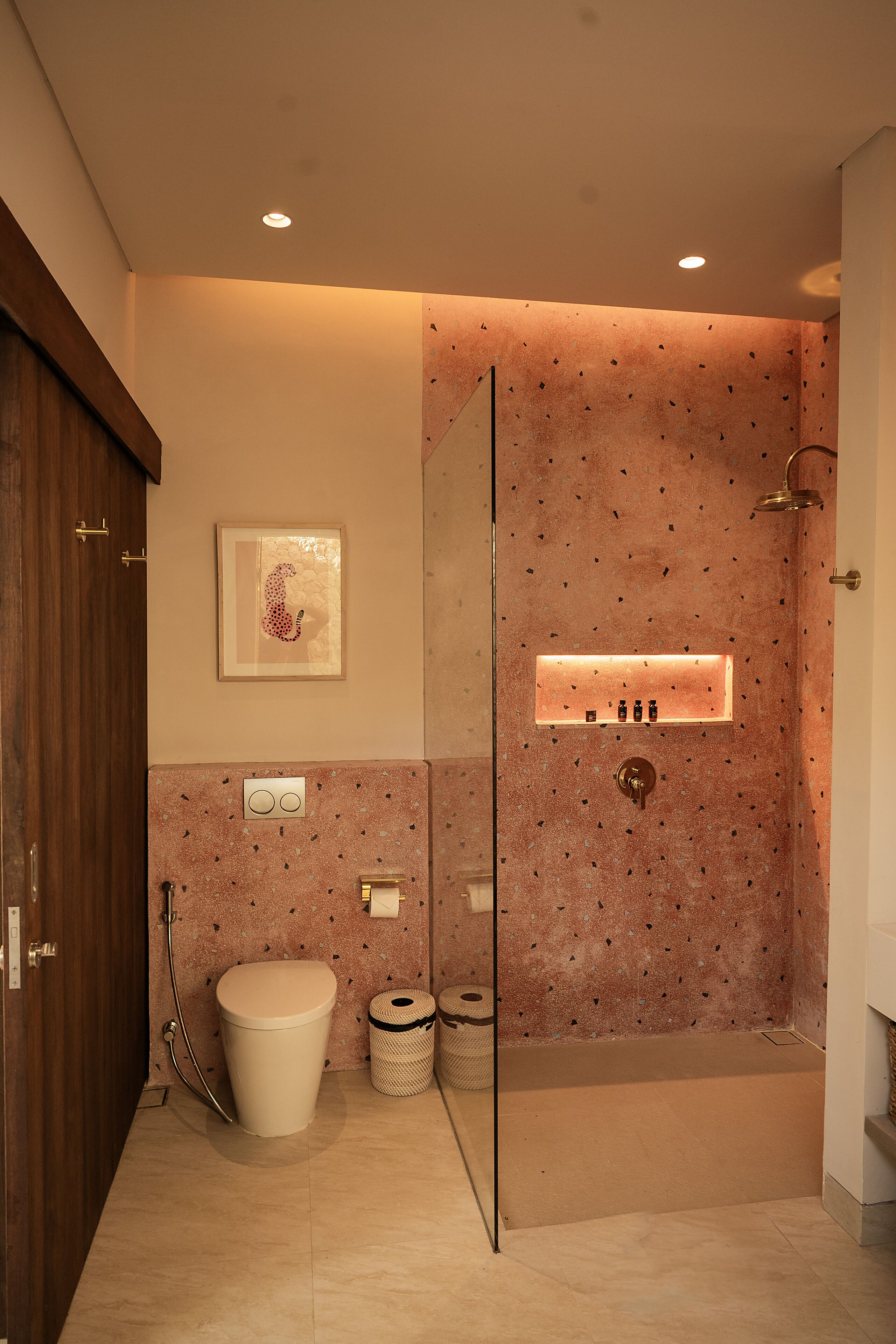A modern bathroom with a glass-enclosed shower, a toilet, and a sink.