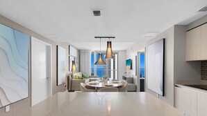 Una cocina moderna con una isla central, iluminación colgante y vistas a la ciudad.