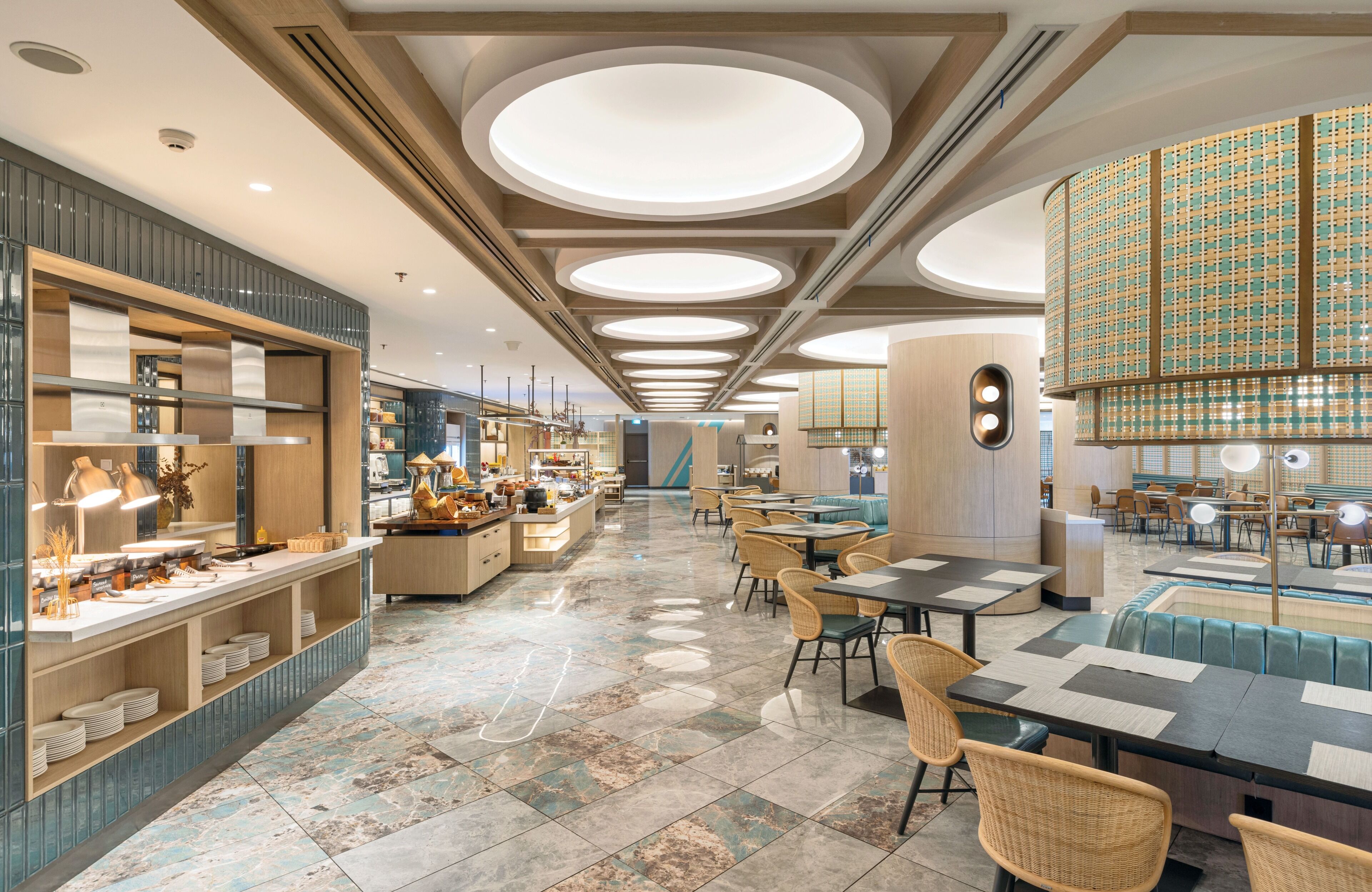 A modern restaurant with a central bar, seating areas, and a decorative ceiling.