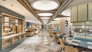A modern restaurant with a central bar, seating areas, and a decorative ceiling.