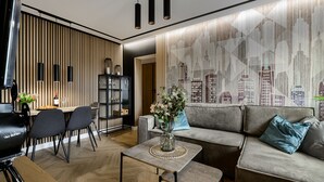 A modern living room with a sofa, a coffee table, and a dining area with chairs and a table. - Mokotów Sobieskiego (Warsaw)