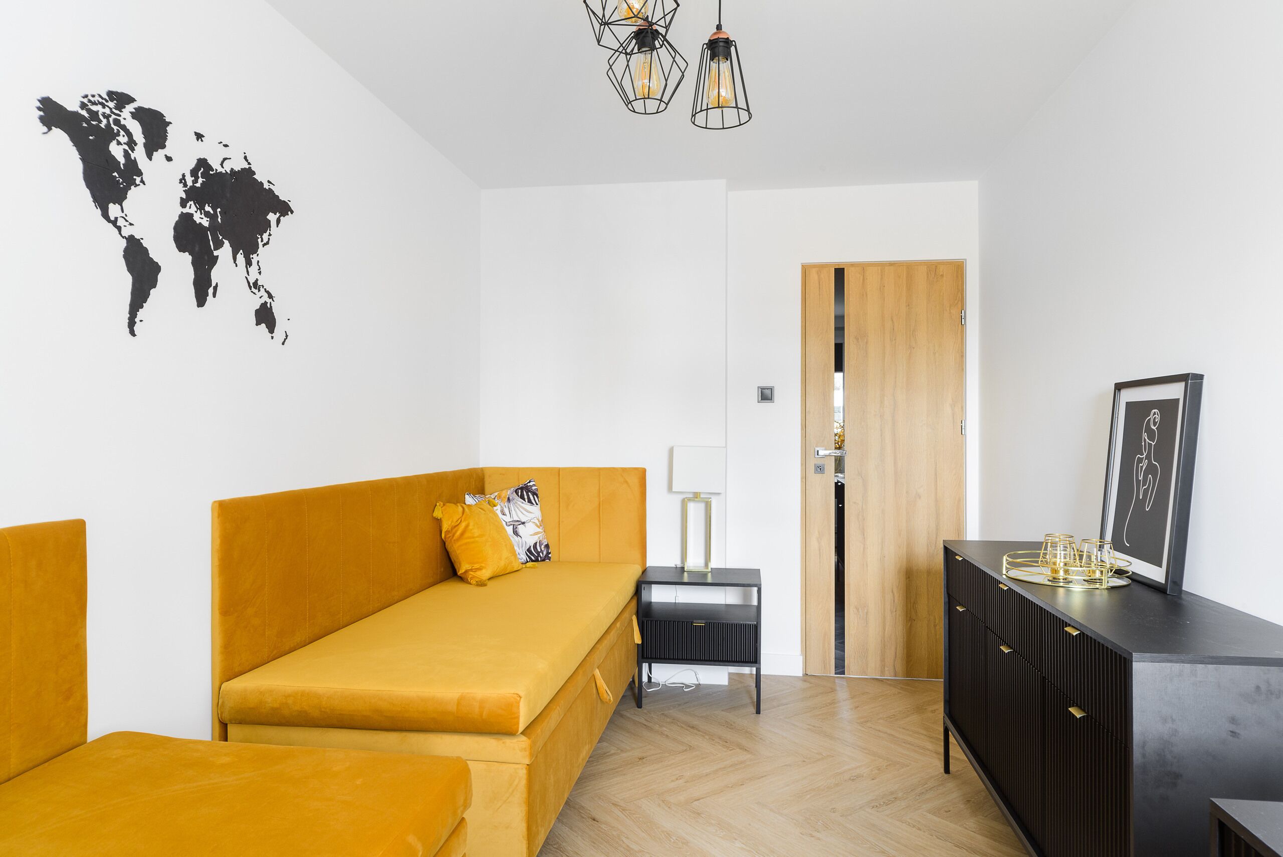 Quarto moderno com sofá, uma mesinha, armário e um mapa-múndi na parede.