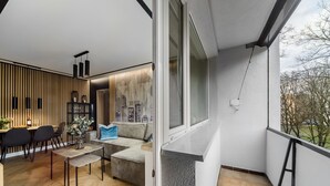 A modern living room with a dining area, a sofa, a coffee table, and a view of the outdoors. - Mokotów Sobieskiego (Warsaw)