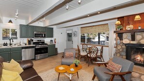 Un salón comedor amplio con chimenea, zona de comedor y cocina equipada con electrodomésticos modernos.
