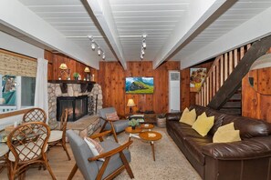 A cozy living room with a fireplace, comfortable seating, and a television.