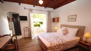 Une chambre à coucher avec un lit, des tables de chevet, un bureau et des chaises.