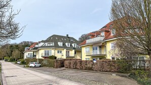 A residential street with houses, a paved sidewalk, and parked cars. - Apartment Ritter by Interhome (Koserow)