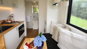 A compact kitchen with a stove, sink, and a dining area with a table set for a meal.