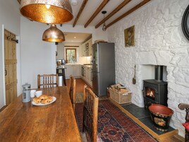 Una cocina acogedora con una mesa de madera, una estufa y una pared de piedra.