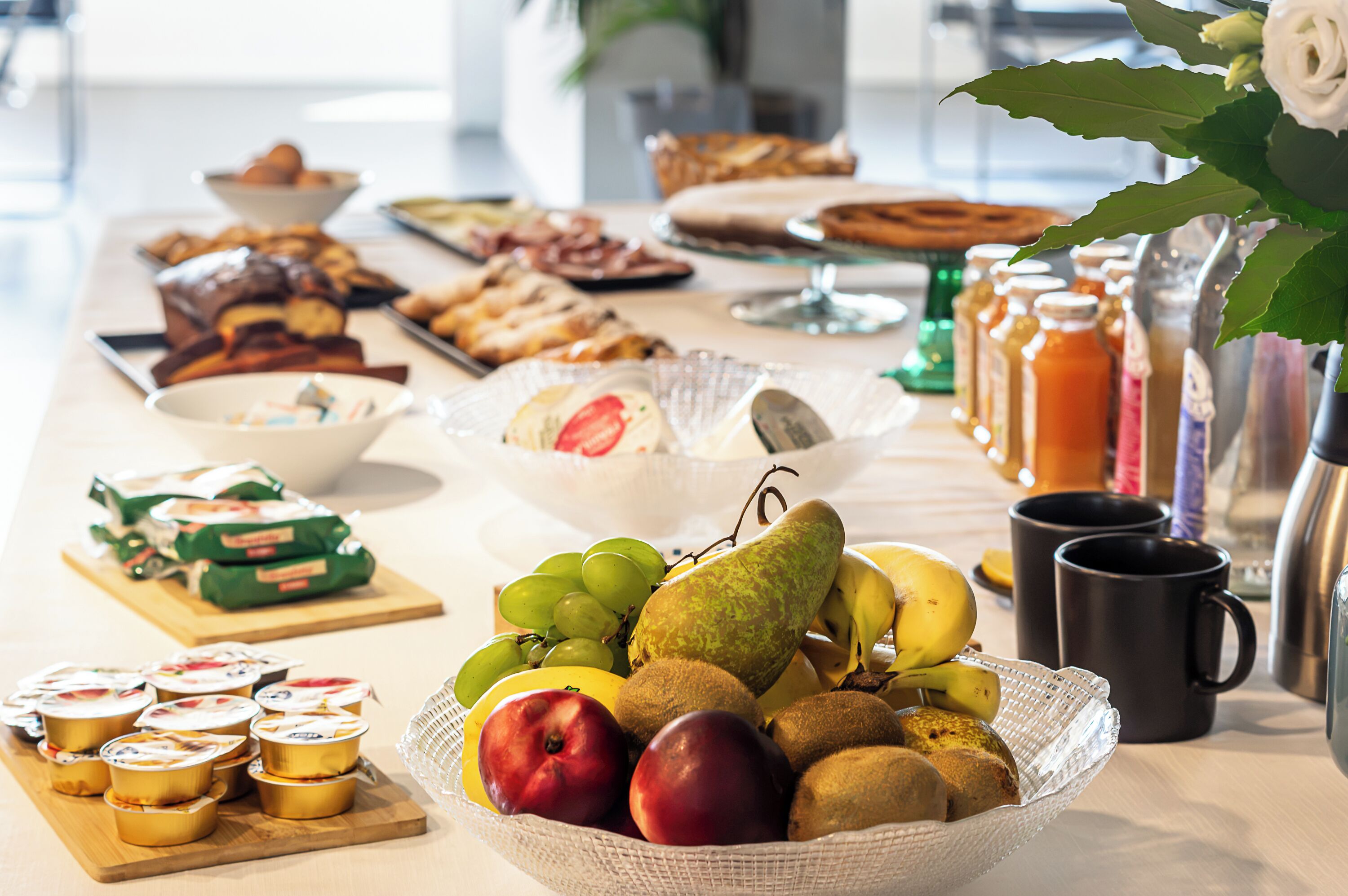 Una mesa de buffet con diferentes alimentos, como frutas, pasteles y salsas.