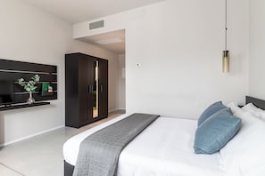A modern bedroom with a bed, bedside tables, a wardrobe, and a wall-mounted TV. - Feudo Antico (Tollo)