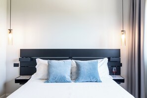 A modern hotel room with a large bed, two bedside tables, and a headboard. - Feudo Antico (Tollo)