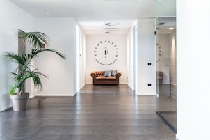 Un interior moderno con un sofá de cuero, una planta en maceta y una pared con un diseño circular.