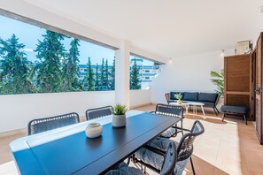 A modern outdoor dining area with a table, chairs, and a view of the cityscape. - Balaia apartment at Albufeira (Albufeira)