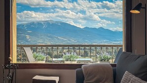 A balcony with a view of mountains, a sofa, and potted lavender plants. - Cal Gatesques 1 (Puigcerda)