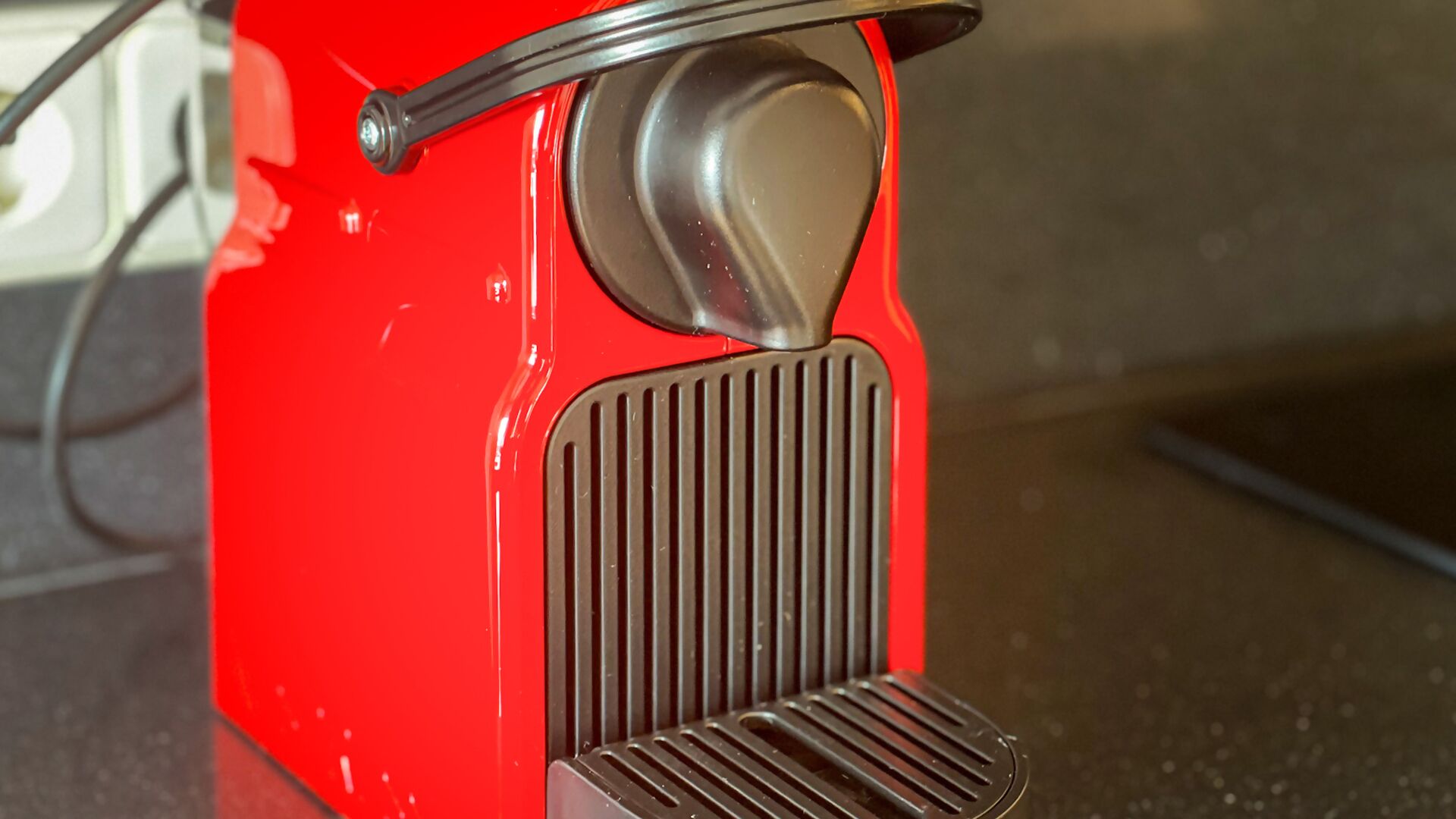 A red appliance with a metallic knob and a vented front panel.