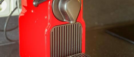 A red appliance with a metallic knob and a vented front panel.