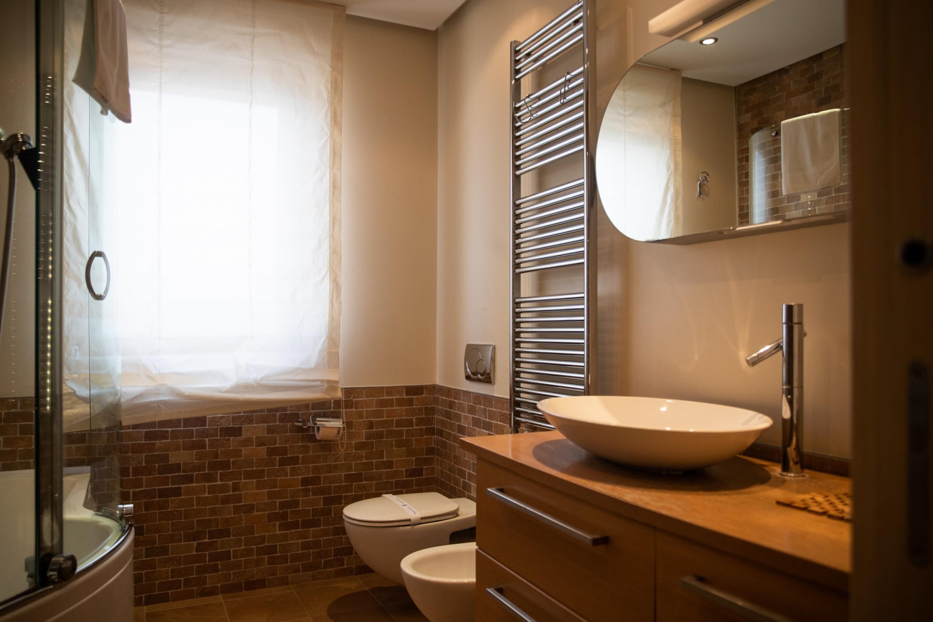A modern bathroom with a glass-enclosed shower, a white sink, and a mirror above the vanity.
