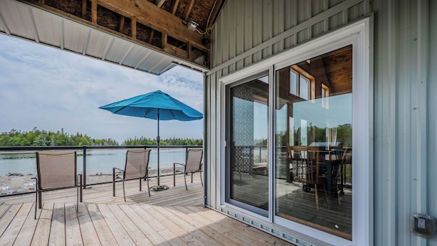 A wooden deck with outdoor seating and a large sliding glass door.