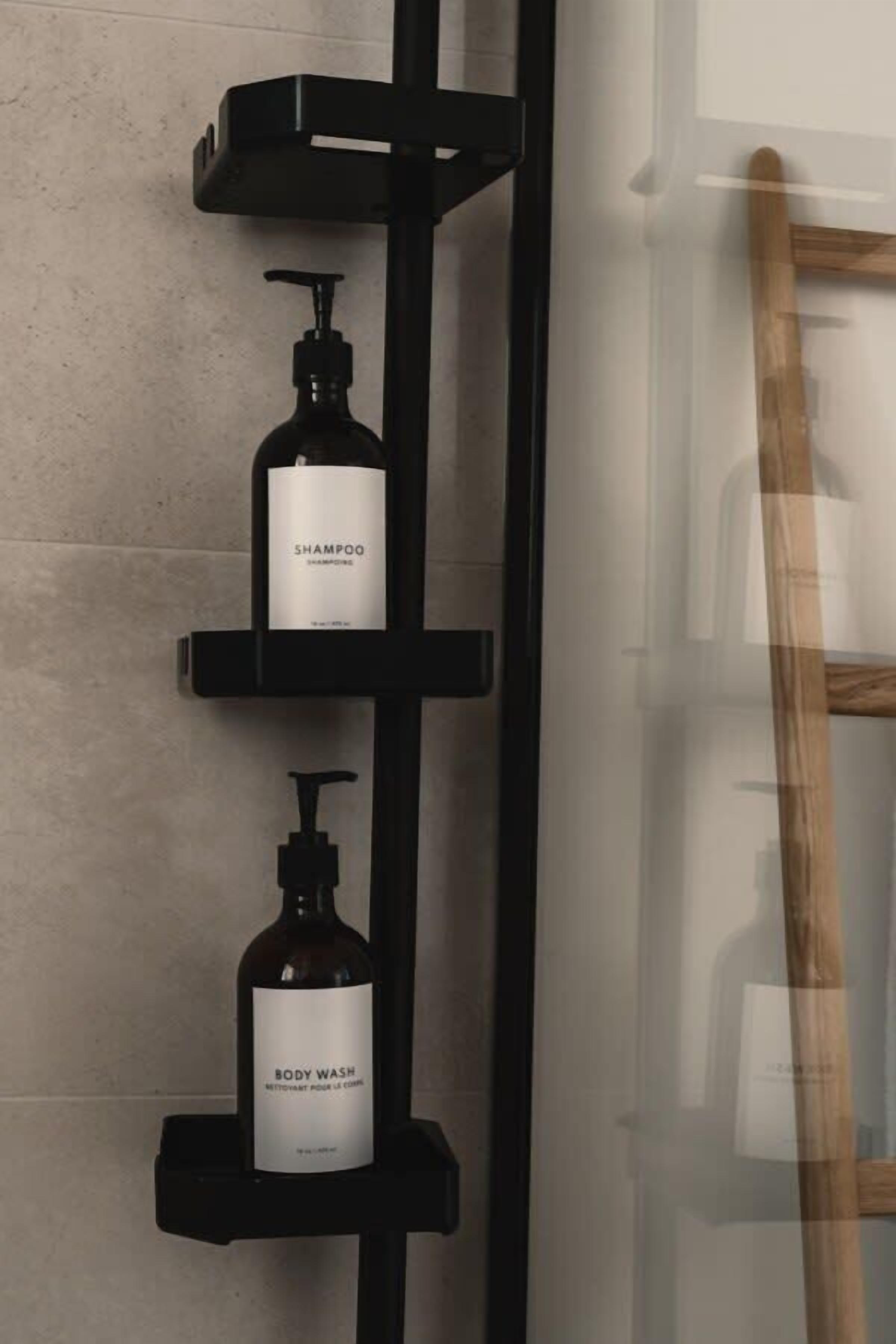 Een badkamer met een zwart schap waarop twee flessen shampoo en douchegel staan.