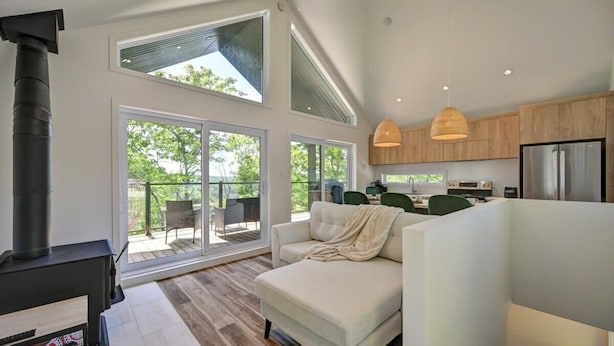 Un espacio habitable moderno con chimenea, sofá, comedor y cocina.