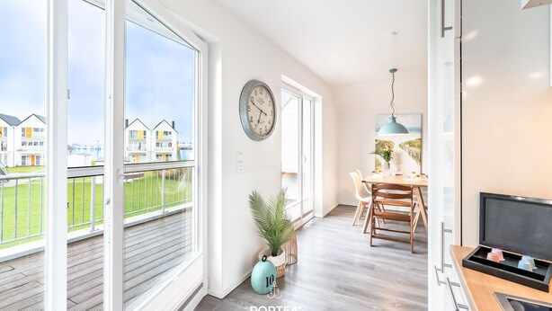 Un appartement moderne doté de grandes fenêtres, d’un coin repas et d’un espace de vie.