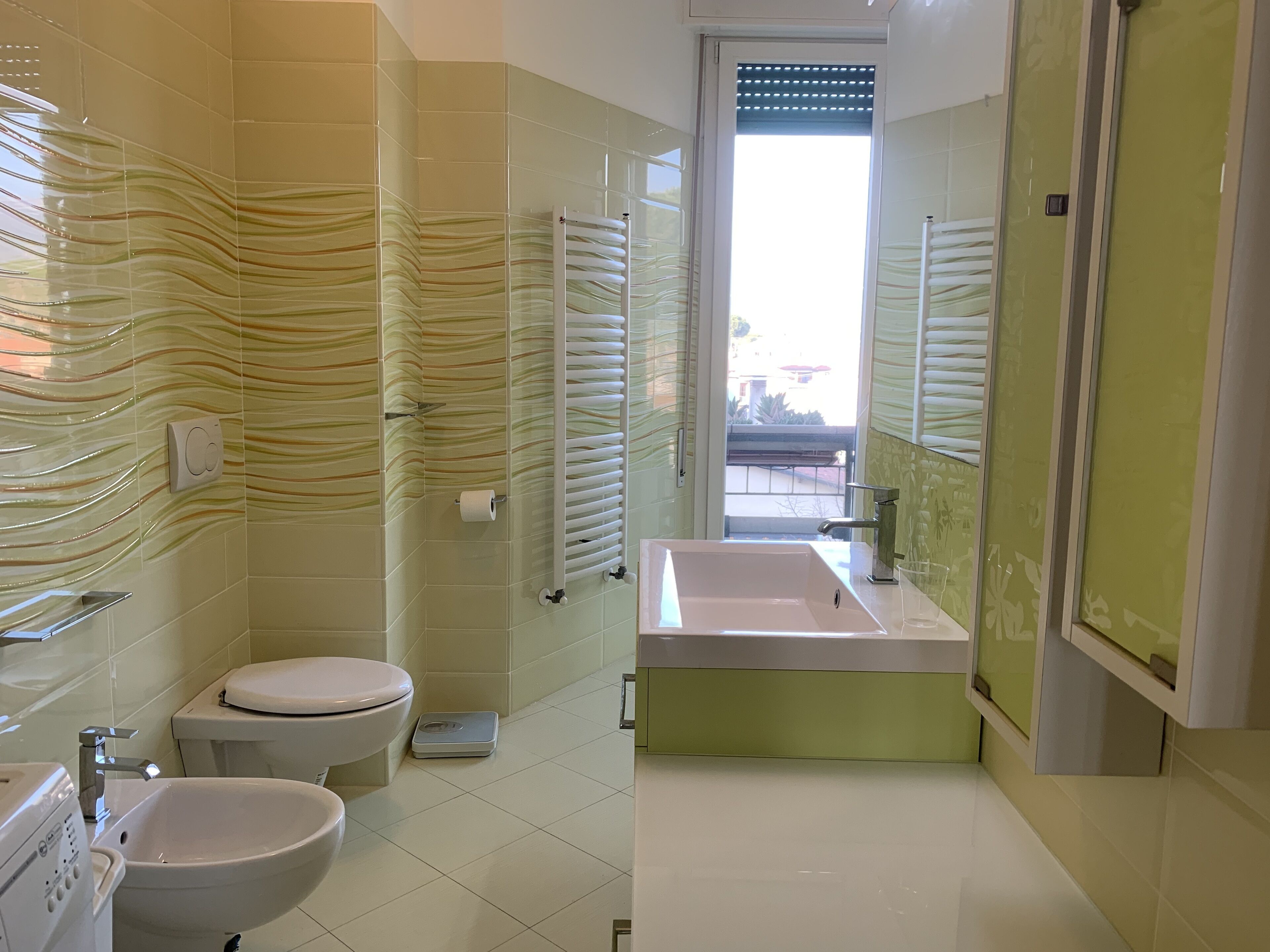 Uma casa de banho moderna com sanita, bidé e lavatório.