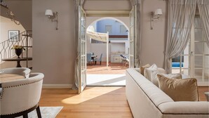 A spacious living area with a sofa, a dining table, and a view of an outdoor patio with a pool. - Stunning home in Vabriga (Vabriga)