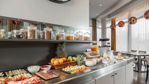 A breakfast buffet with various food items and a fruit basket. - Welcome Hotel (Serravalle)
