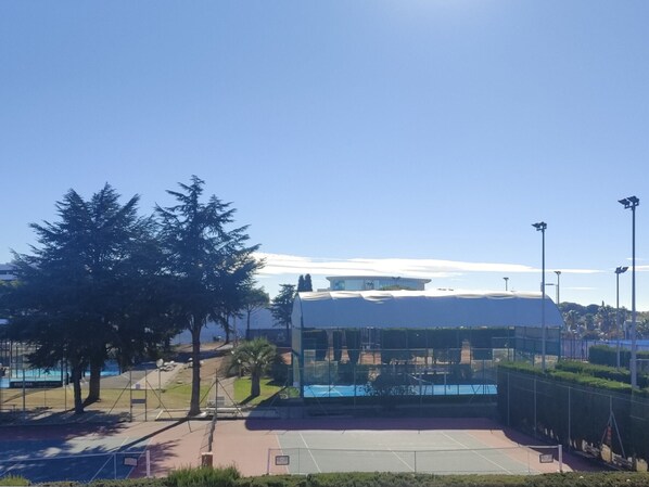 A sports facility with a tennis court, a covered seating area, and a large building with a dome roof. - Cozy 2-Room Apartment with Gym Access and Terrace, A/C, Parking – Sleeps 4 in Agde (Cap d'Agde)