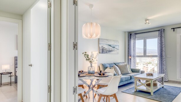 Ein modernes Wohnzimmer mit Essbereich, ausgestattet mit einer Couch, Stühlen, einem Couchtisch und einem Esstisch.