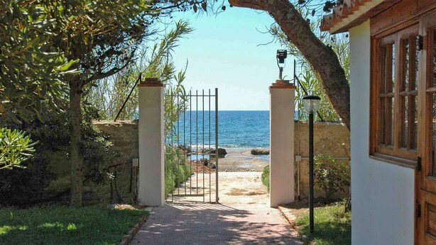 A pathway leading to a beach with a gate and lamp posts. - Amazing home in Siracusa (Siracusa)