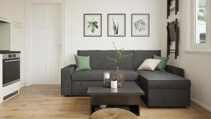A modern living room with a grey sofa, a coffee table, and framed botanical prints on the wall.