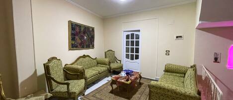 A living room with two sofas, a coffee table, and a patterned rug.