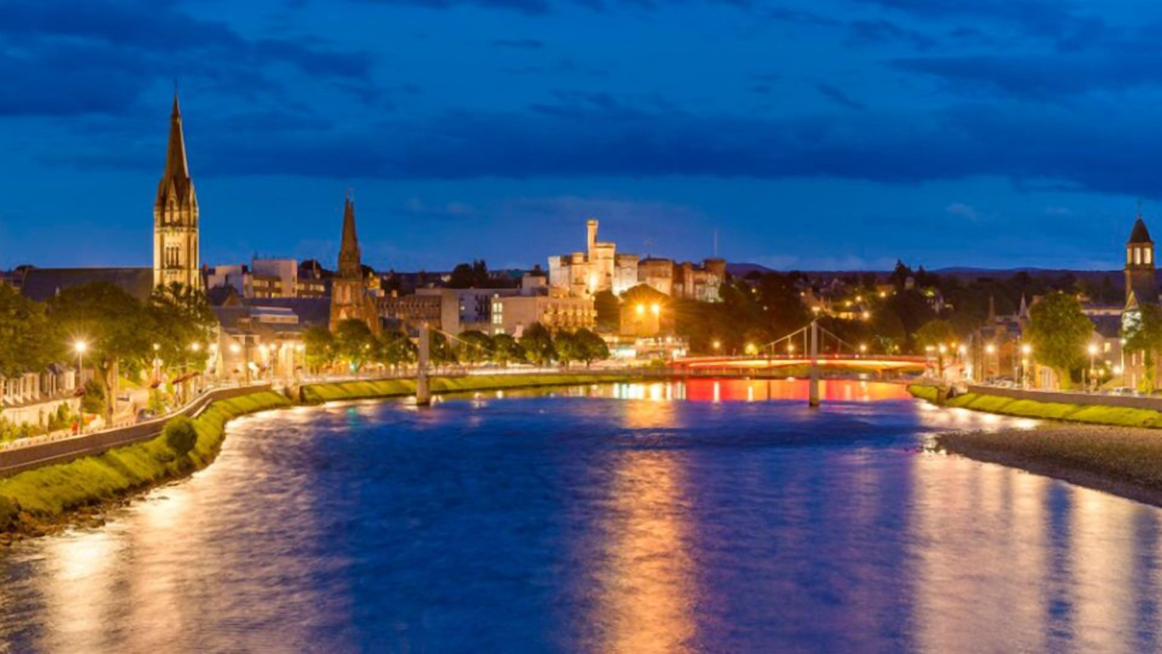 Un río con un puente y edificios al fondo.