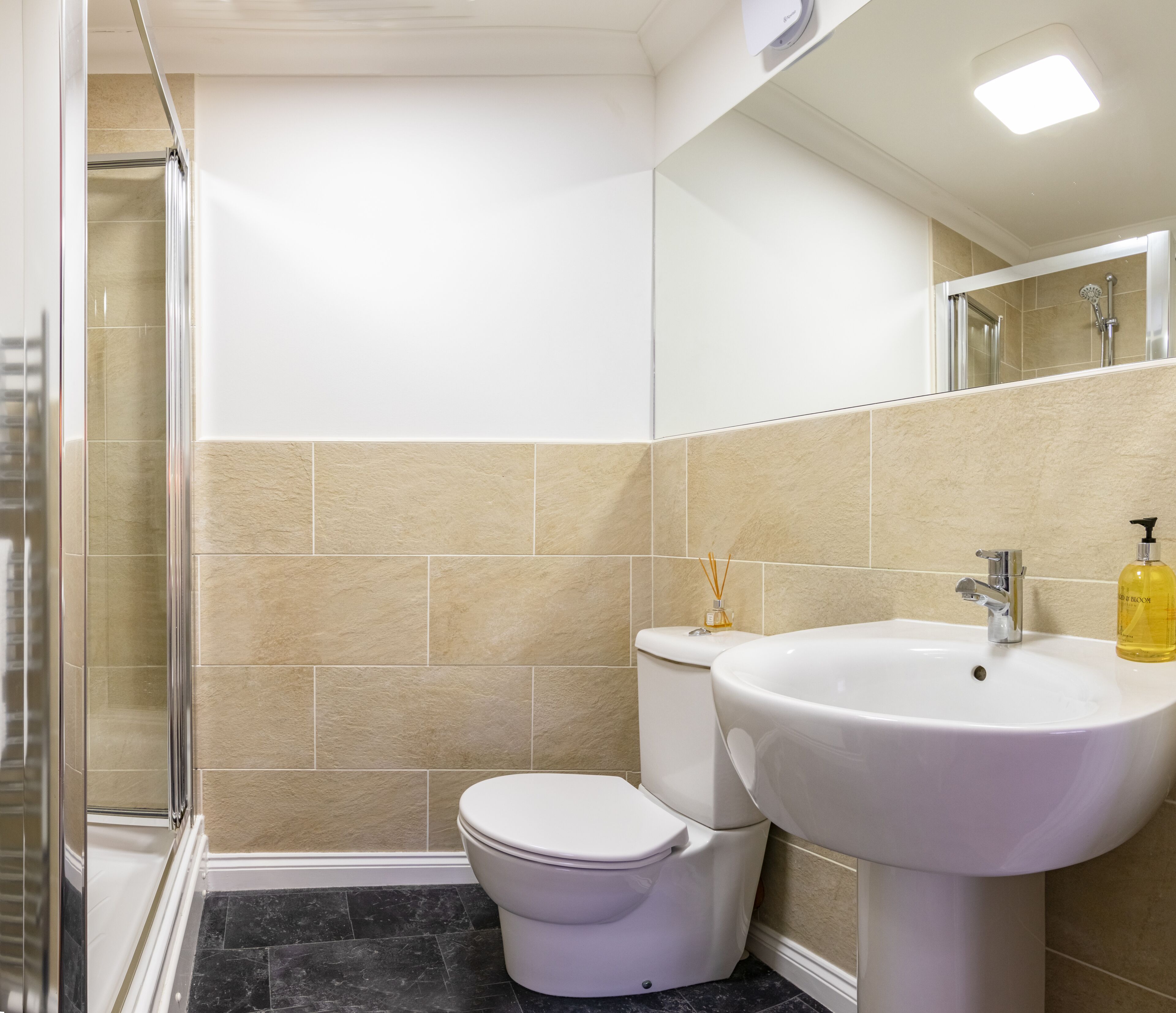 A bathroom with a shower, toilet, and sink.