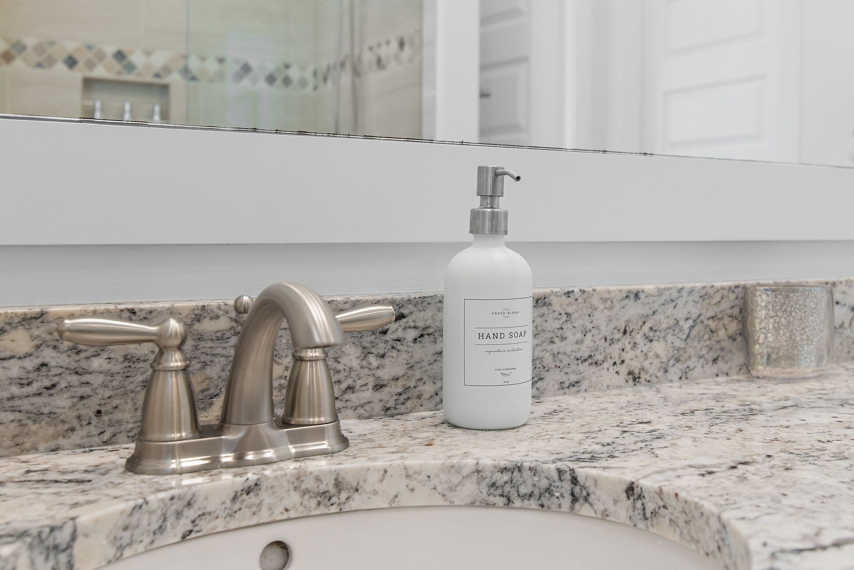 Un lavabo de salle de bain doté d’un robinet moderne et d’un distributeur de savon liquide.