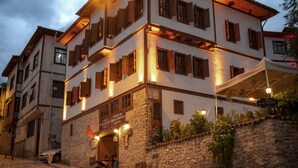 A multi-story building with a stone facade, a covered entrance, and a sign indicating it is a hotel. - KOLAĞASI KONAK (Safranbolu)