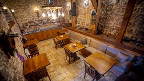 A rustic stone interior with wooden furniture, stone walls, and a stone floor. - KOLAĞASI KONAK (Safranbolu)