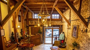 A rustic interior with stone walls, wooden beams, a stone staircase, and a cozy seating area with a fireplace. - KOLAĞASI KONAK (Safranbolu)